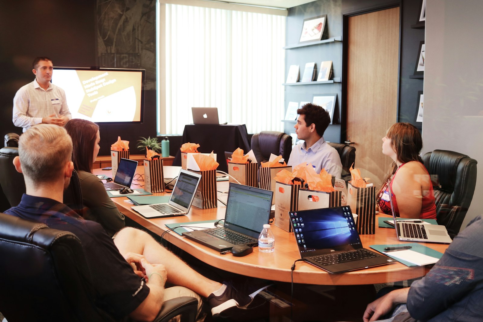 Team meeting around a conference table with laptops